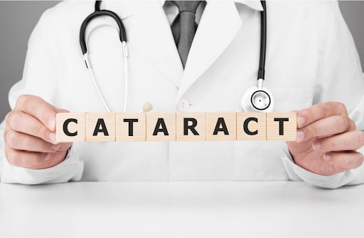 A doctor holding up block letters that spell out "cataract"